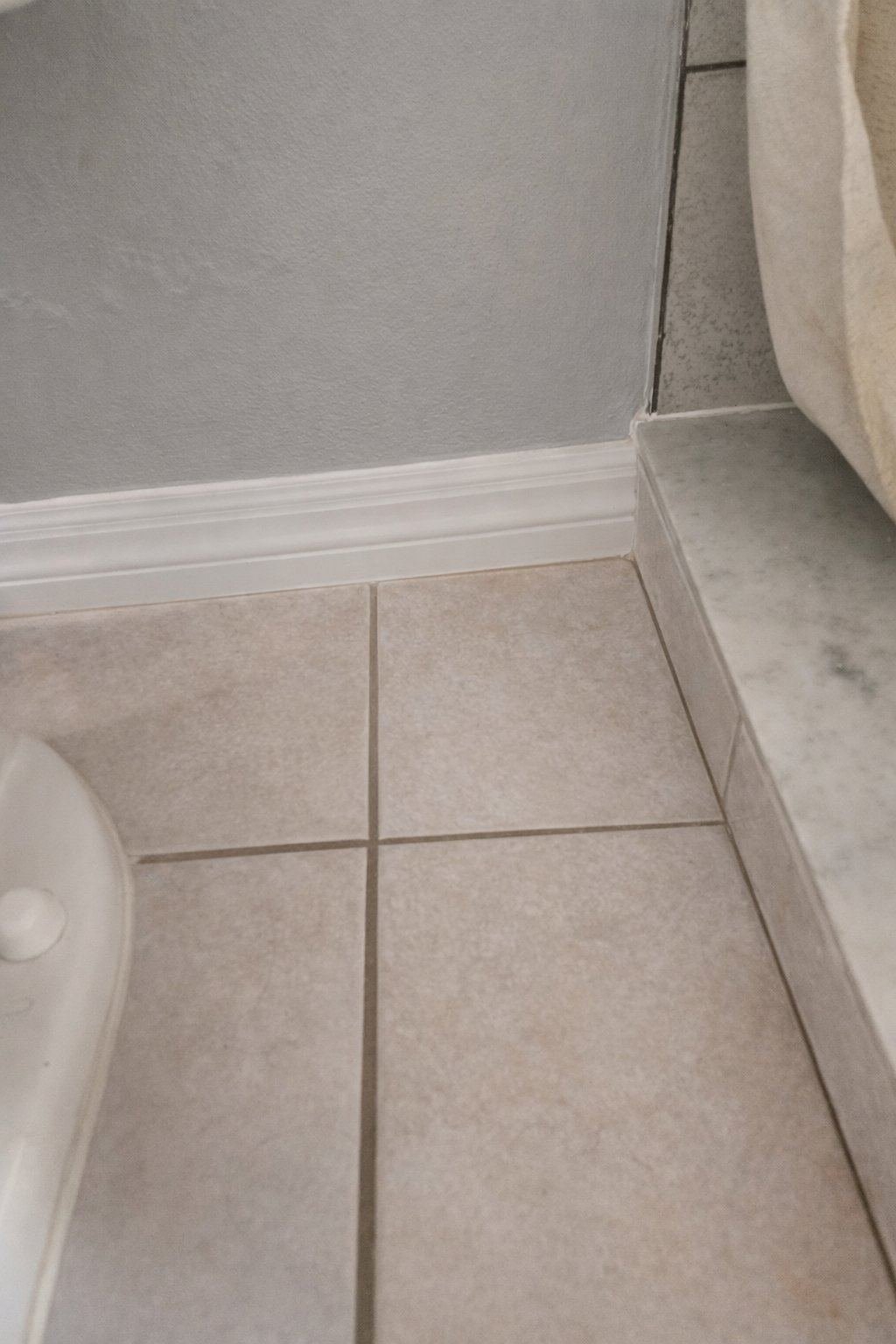 Restored tile grout and repaired baseboard in Fort Myers FL bathroom